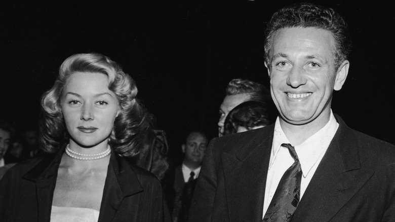 Gloria Grahame and Nicholas Ray walking through a crowd