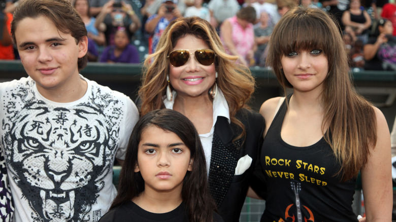 Prince, Paris, Blanket, and La Toya Jackson smiling at a baseball game in 2012