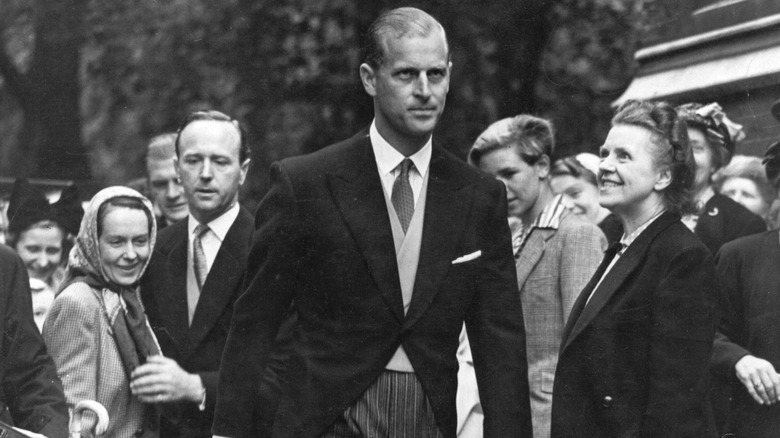 Prince Philip walks with Mike Parker in the background through adoring fans