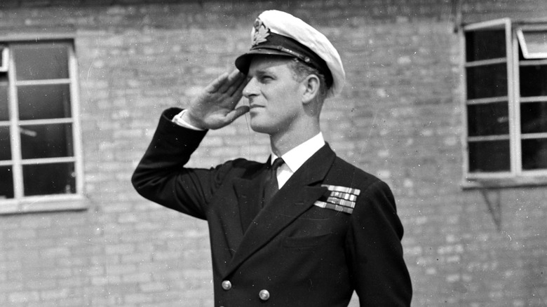 A young Prince Philip performing a military salute in military uniform
