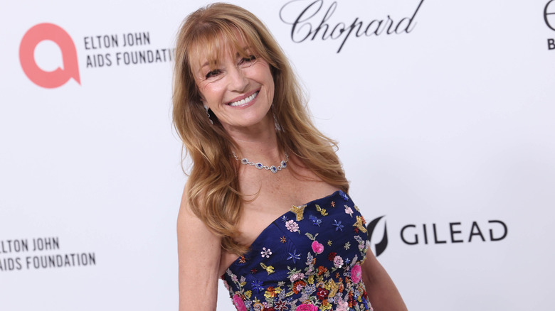 Smiling Jane Seymour wearing a strapless navy gown on the red carpet.