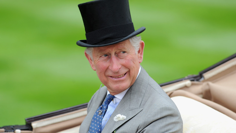 King Charles III smiling in top hat 