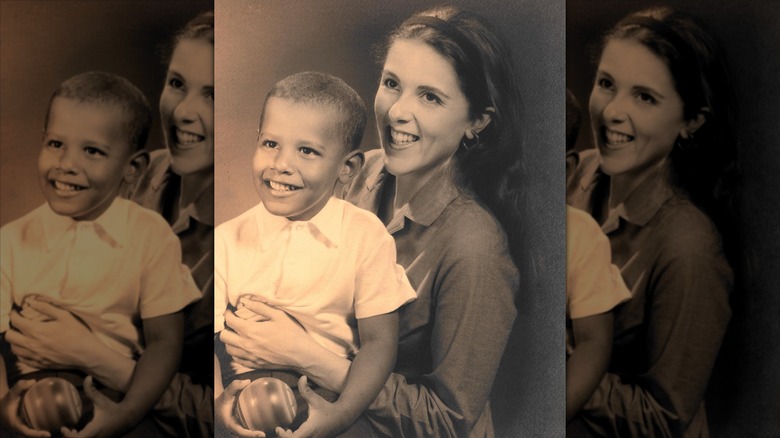 Barack Obama as a child smiling and sitting on his mother's knee