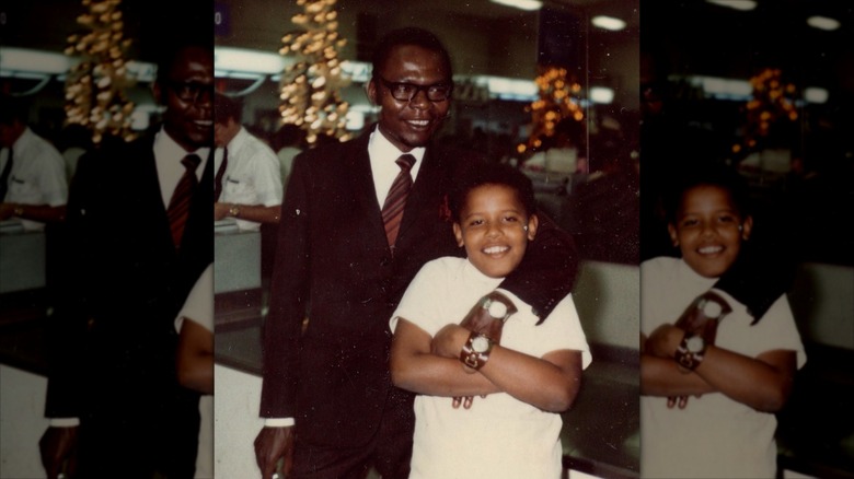 Young Barack Obama smiling with his father who has his arm around his son