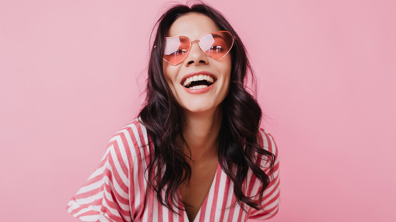 Woman wearing pink heart sunglasses