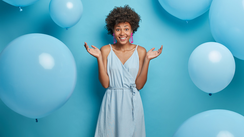 Model in a blue dress surrounded by blue balloons