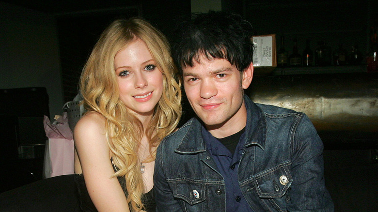 Deryck Whibley wearing a denim jacket beside Avril Lavigne in 2005