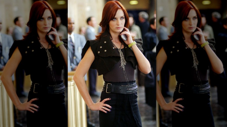 Emily Blunt as Emily wearing a black dress, bolero, and sideways belt in "The Devil Wears Prada."