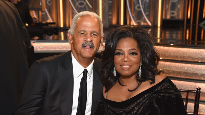 Oprah Winfrey and Stedman Graham sitting at a table in black formals.