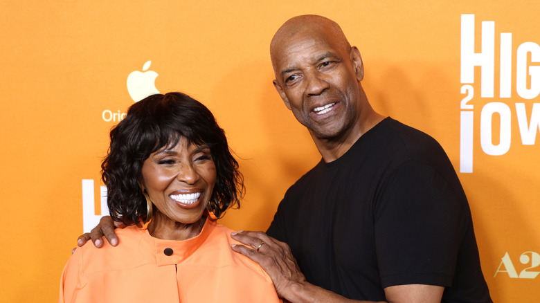 Denzel Washington holding Pauletta Washington smiling at an event for his film Highest 2 Lowest.