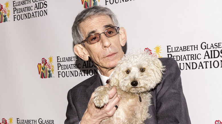 Richard Belzer posing with small white dog