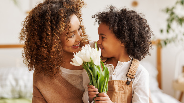 Woman getting white tulips from her child