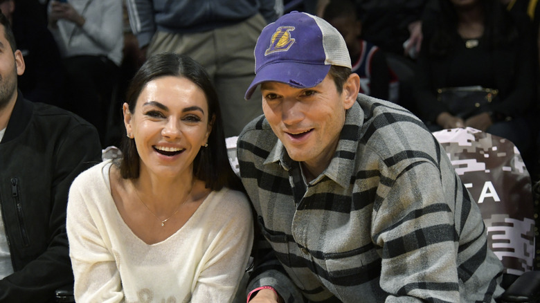 Ashton Kutcher in a Lakers cap with Mila Kunis
