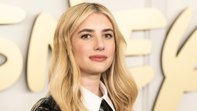Emma Roberts half-smiling at a red carpet event.