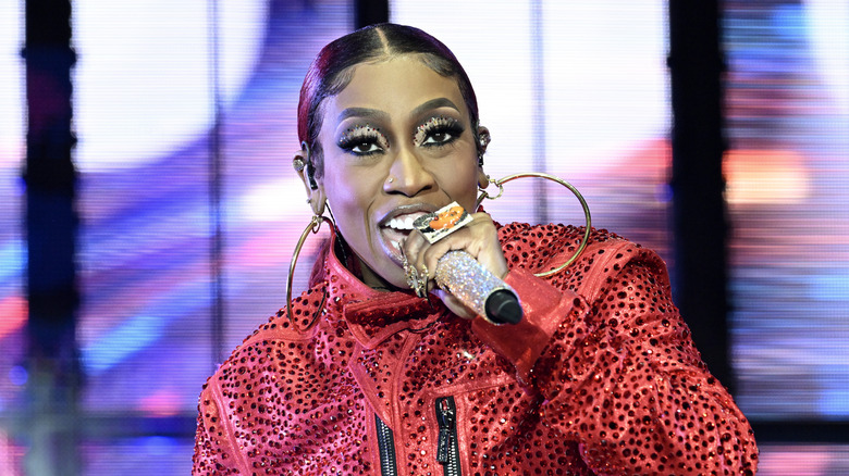 Missy Elliott singing or rapping into a microphone.