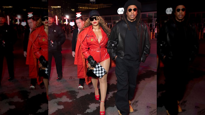 Beyoncé wearing red Ferrari one-piece and walking with Jay-Z