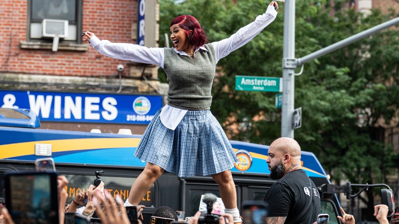 Cardi B standing on top of a car during her pop-up event