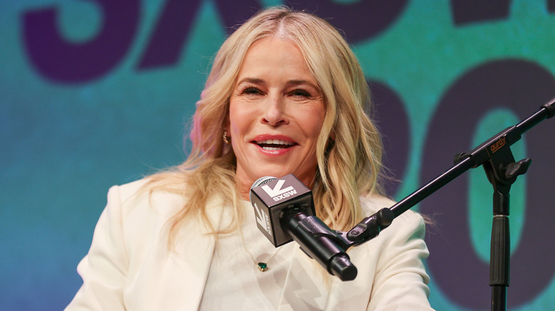 Chelsea Handler in a white suit speaking on a mic