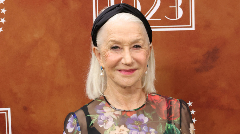Helen Mirren wearing a black headband and floral outfit