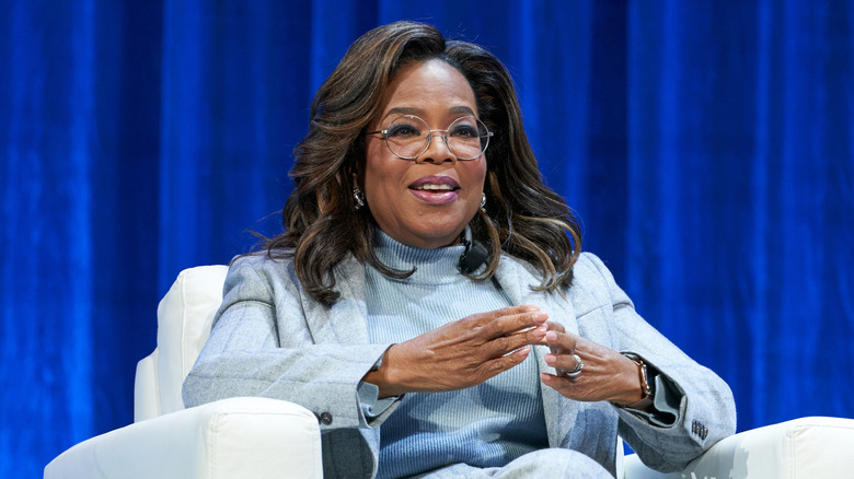 Oprah Winfrey in a blue suit against a blue background
