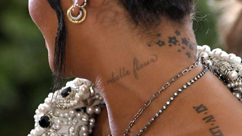 Rihanna's neck tattoo says "rebelle fleur"