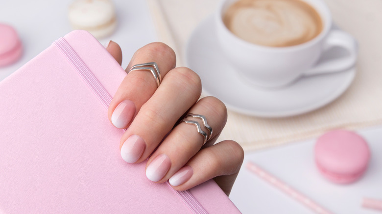 Pink ombré nails against pink notebook