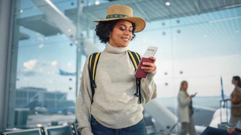 A woman smiles down at her passport 