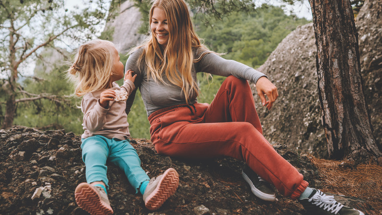 Smiling woman and child sitting woods