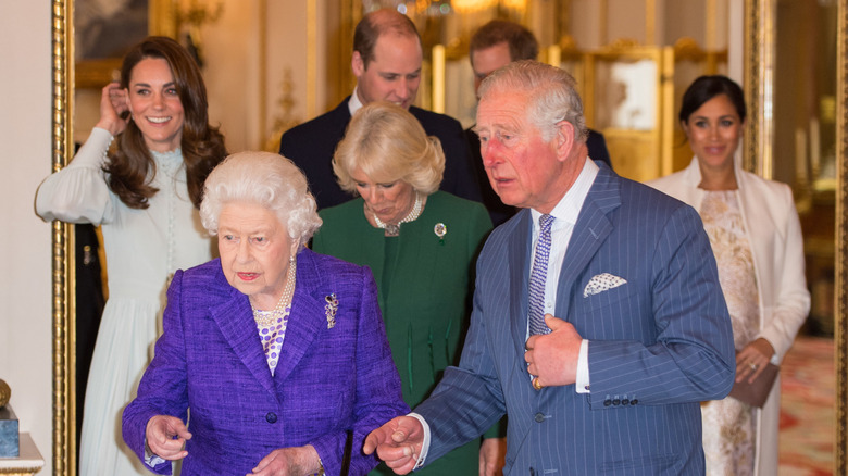 Queen Elizabeth II, King Charles III, Kate Middleton, Camilla Parker Bowles, Prince William, Prince Harry, and Meghan Markle walking together