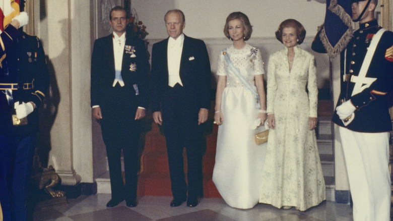 Betty Ford posing with Gerald Ford and Spanish royalty in a green dress