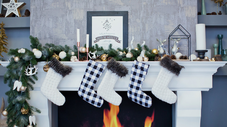 Fireplace mantel with plaid stockings and pine garland