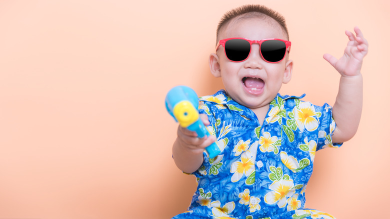 baby boy holding water gun