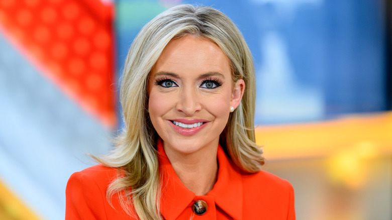 Kayleigh McEnany smiling and wearing an orange blazer