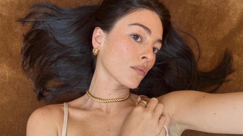 A selfie of Analuisa Corrigan, with her hair spread out on a brown background.