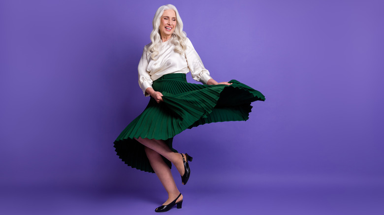 Woman dancing on feet in green pleated skirt