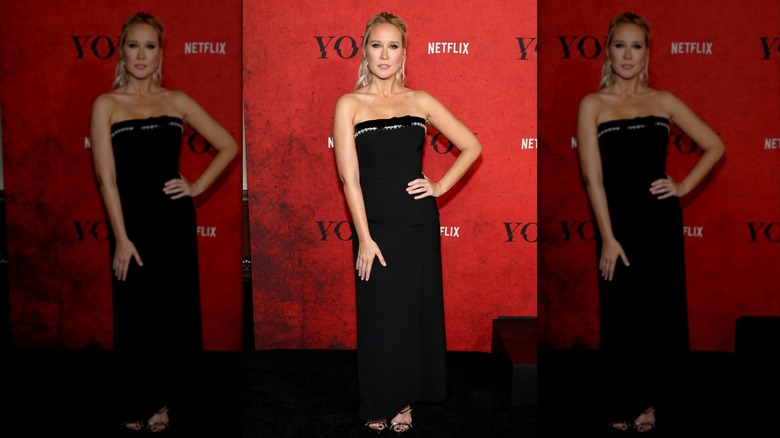 Anna Camp in a strapless black dress with white trim detailing at an event