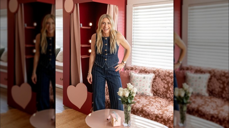 Jasmine Roth in a denim suit in a red room