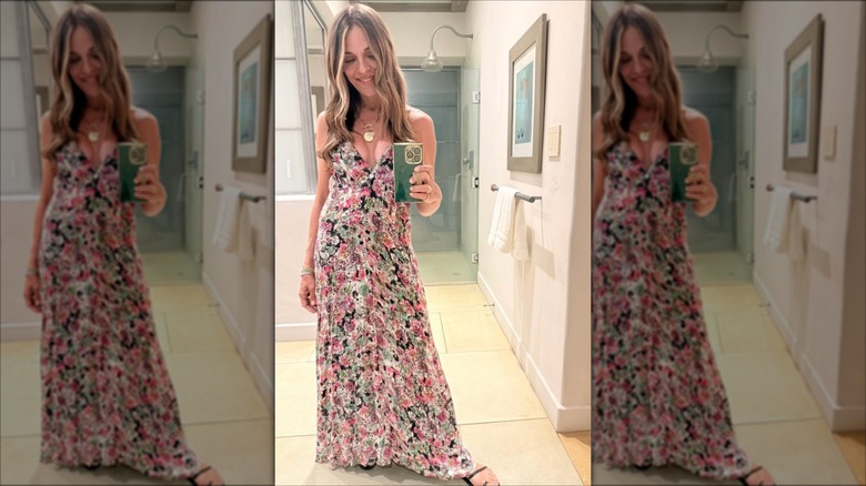 Sabrina Soto in a floral dress with black sandals taking a selfie