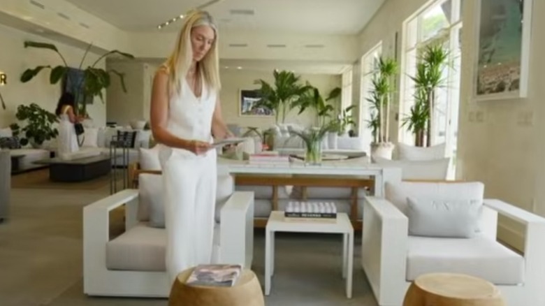 Sarah Baeumler in a white vest and pants in a minimalist room
