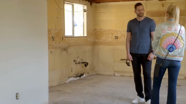 Tarek El Moussa in a fixer upper house with Heather Rae El Moussa talking to him
