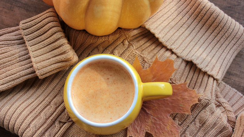 sweater, yellow mug, and leaf