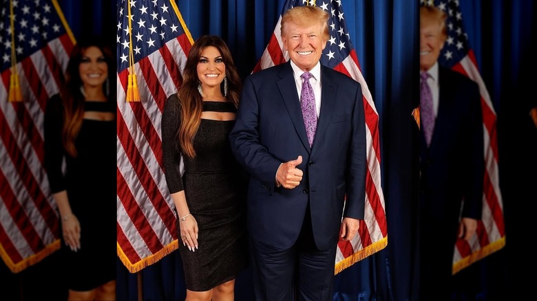 Kimberly Guilfoyle poses with Donald Trump in front of two American flags