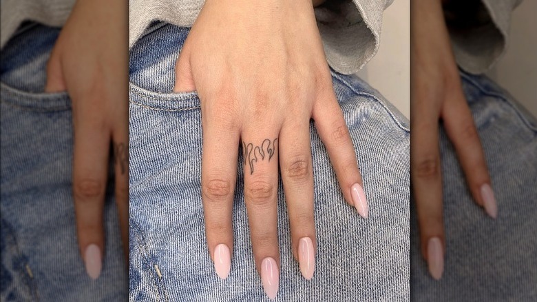 Hand with flame tattoo in pocket