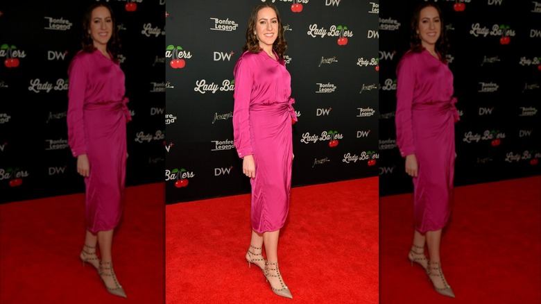 Chaya Raichik poses on a red carpet in a pink dress