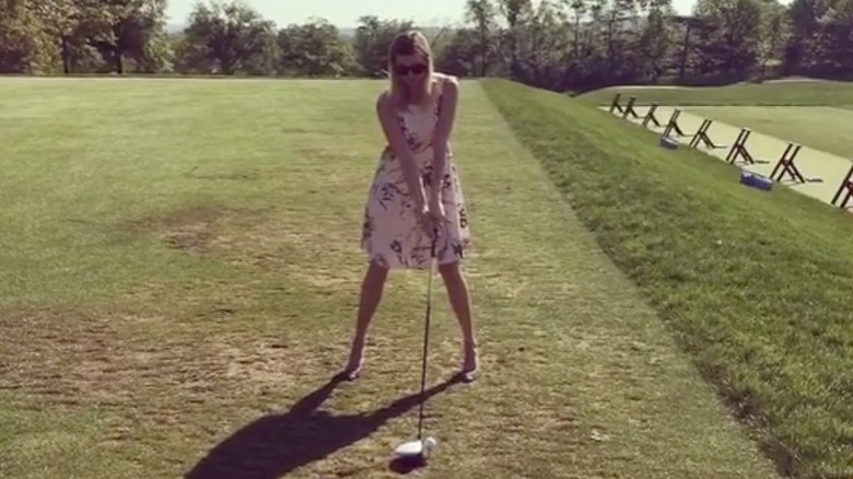 Ivanka Trump about to swing a golf club in heels