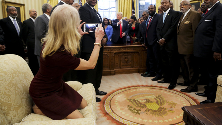 Kellyanne Conway kneels on the couch at the oval office