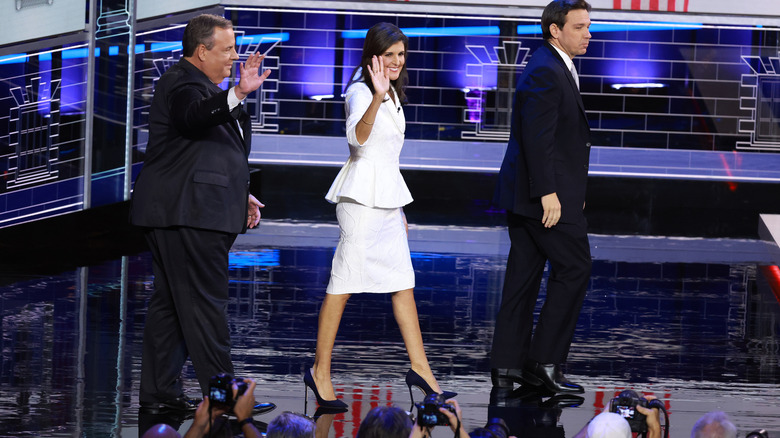 Nikki Haley waves as she walks onstage with two male politicians