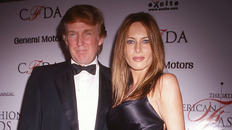 Melania Trump in a grey dress and Donald Trump in a tuxedo at an event in 1999