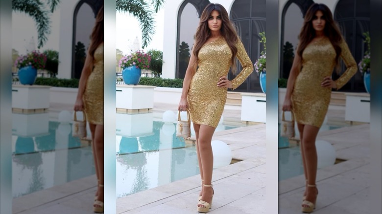 Kimberly Guilfoyle posing for a photo in a gold dress beside a pool