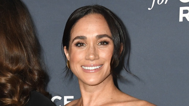 Close-up fo Meghan Markle smiling on step-and-repeat